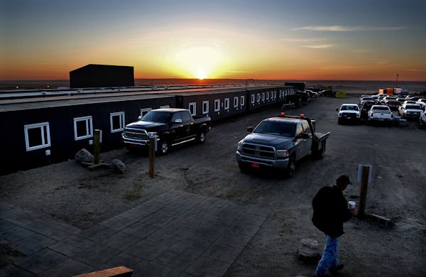 The sun rose over a man camp in Williston, where Army buddies Ben Lewis and Jake Edgren were staying while working in the Bakken oil fields.