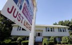 FILE - In this Wednesday, Sept. 18, 2013, file photo, a "For Sale" sign hangs in front of a house in Walpole, Mass. 0