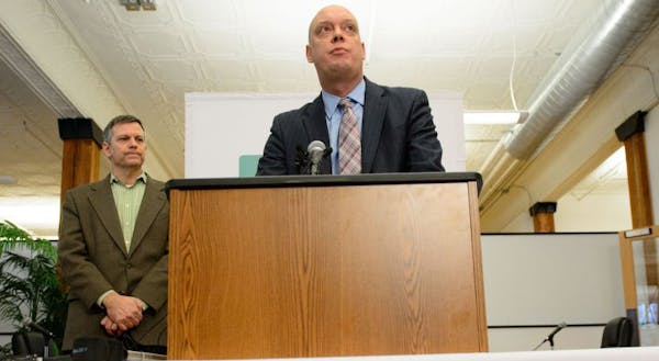 MNsure Chairman Brian Beutner, left, listens as interim CEO Scott Leitz speaks during a press conference Wednesday.