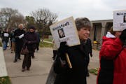 Diane Plocher, of Mayer, braved the cold and wind along with other protesters to march for the resignation of Archbishop John Nienstedt across the str