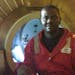 In this image made available Tuesday Dec. 3, 2013, Harrison Odjegba Okene poses for a portrait inside a decompression chamber after being rescued from