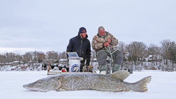 Frank Weeda, left, of Shoreview and Dick “Griz’’ Grzywinski of St. Paul re-rigged a tip-up on a Chisago Lakes area lake Friday morning. Winter a