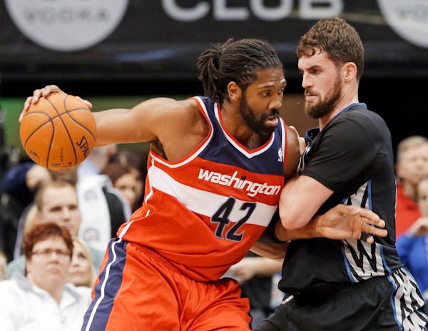 Minnesota Timberwolves' Kevin Love, right, slows Washington Wizards' Nene Hilario on a drive during the first quarter of an NBA basketball game, Frida