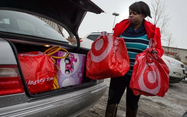Janelle Borward loaded bags of supplies and gifts into her car after shopping the Midway Target store in St. Paul on Dec. 19, 2013.