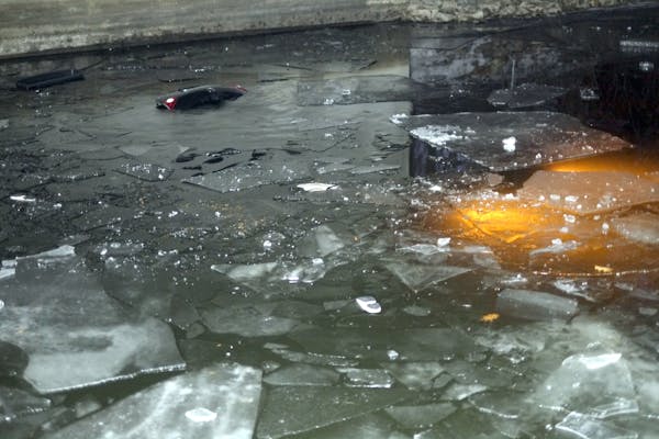 Lights from a submerged vehicle under a bridge across a Lake Minnetonka channel on Friday. The car went through the ice with four people inside, inclu