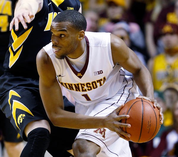 Minnesota guard Andre Hollins (1) looks to pass to a teammate under pressure from Iowa guard Mike Gesell, left, during the first half of an NCAA colle