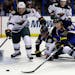 St. Louis Blues' T.J. Oshie (74) and Minnesota Wild's Ryan Suter (20) reach for a loose puck during the second period of an NHL hockey game Thursday, 