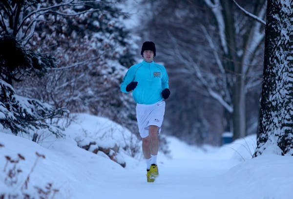 John Ziegler of Minneapolis decided to defeat the newest snowfall by running in shorts during his early run, Wednesday, March 19, 2014.