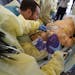 Surgical residents along surgical residents along with experienced surgeons train on a mannequin at the Surgical Simulation and Training Laboratory in