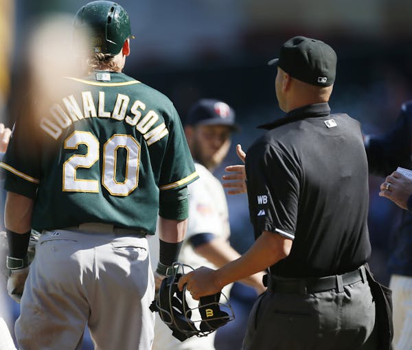 Umpire Vic Carapazza got between Oakland’s Josh Donaldson and Twins lefthander Glen Perkins after the end of the top of the 10th inning. Words were 