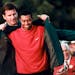 FILE - In this April 13, 1997, file photo, Masters champion Tiger Woods receives his green jacket from the previous year's winner Nick Faldo, rear, at