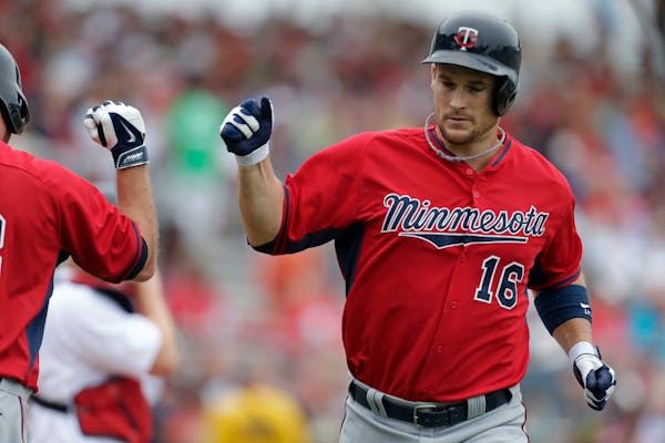 Minnesota Twins' Josh Willingham (16) is greeted by Jason Kubel after hitting a solo home run during the second inning of an exhibition baseball game 