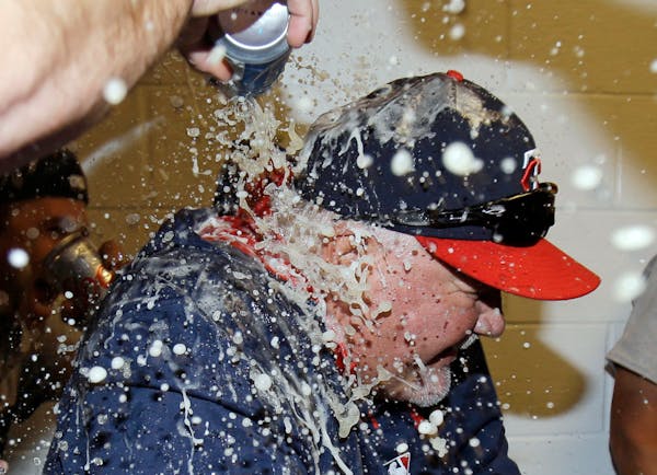 Minnesota Twins manager Ron Gardenhire is doused with beer after the Twins defeated the Cleveland Indians 7-3 in a baseball game, Saturday, April 5, 2