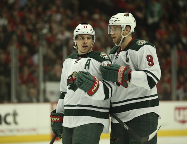 Minnesota Wild left wing Zach Parise (11) and center Mikko Koivu (9) conferred before a late third period faceoff Sunday afternoon at United Center in
