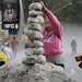 A woman makes a tower using ice from an overnight hailstorm in the Aclimacao neighborhood of Sao Paulo, Brazil, Monday, May 19, 2014. Some told local 