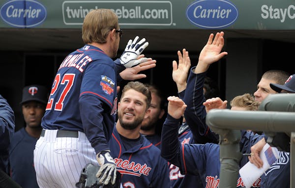Minnesota Twins' Chris Parmelee gets congratulated in the dugout after hitting a two-run home run during the second inning of a baseball game against 