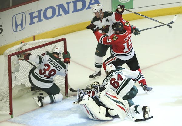 Minnesota Wild defenseman Nate Prosser (39) chases the puck into the goal as Chicago Blackhawks center Jonathan Toews (19) scores during the third per