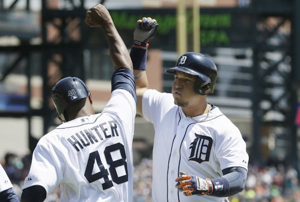 Detroit Tigers' Miguel Cabrera is congratulated by teammate Torii Hunter after they scored on Cabrera's 3-run home run during the second inning of a b