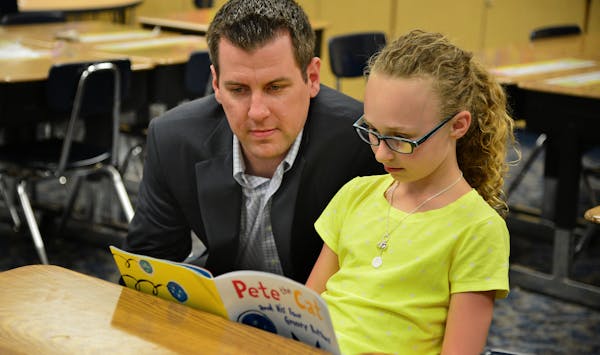 Bremer Bank’s Mike Yanisch helps out students like Ava Matza at Liberty Ridge Elementary in Woodbury.