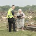 June 16, 2014: Ruth Labenz is assisted to safety by a Stanton County Sherriff's officer after her home was destroyed in the town of Pilger, Neb.