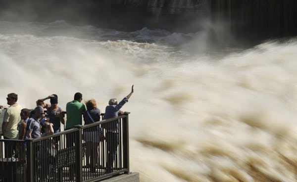 The turbulent water flow at St. Anthony Falls on the Mississippi River in downtown Minneapolis drew observers at Water Power Park on Sunday afternoon.