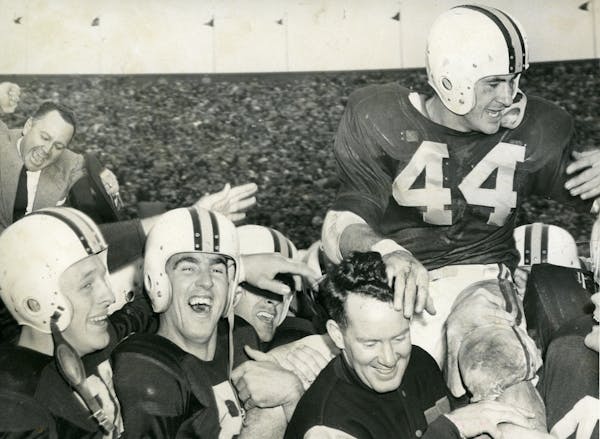 In this 1954 photo, Bob McNamara (44) received a triumphant ride from teammates after leading the Gophers to a victory over Iowa.