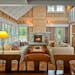 A wood-burning fireplace warms the open main floor, melding open studs and paneled pine walls with reclaimed barnwood floors in the Lake Superior cott