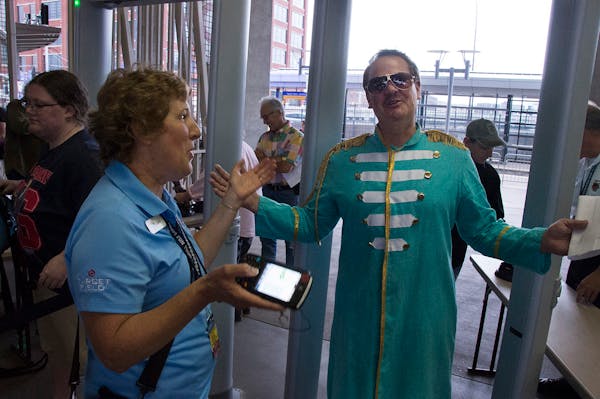Tom Minehart, from Albert Lea, costumed as Sgt.Pepper, passed through a Target Field security gate. His ticket was being taken by Jill Windmuller from