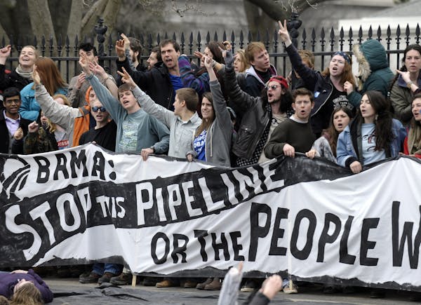 Several hundred students and youth who marched from Georgetown University to the White House to protest the Keystone XL Pipeline yell as they wait to 