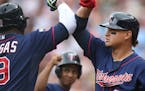 Minnesota Twins' Oswaldo Arcia, right, gives an elbow bump to Kennys Vargas as a ball boy, center, waits his turn after Vargas hit a solo home run off