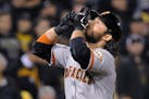 San Francisco Giants' Brandon Crawford points skyward as he heads home after hitting a grand slam during the fourth inning of the NL wild-card playoff