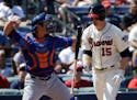 Atlanta Braves' Phil Gosselin, right, flips his bat as he strikes out while New York Mets catcher Anthony Recker, left, throws the ball to the infield