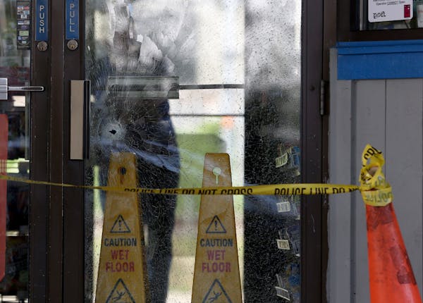 Tuesday: A bullet hole marked a door at the Moto Mart in south Minneapolis, where three people were wounded.