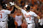 Baltimore Orioles' J.J. Hardy (2) is met at the plate by Ryan Flaherty (3) after his solo home run in the seventh inning against the Detroit Tigers du