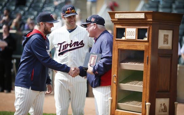 Glen Perkins, left, and Joe Mauer congratulated Ron Gardenhire after the Twins manager was given the gift of a custom humidor after posting his 1,000t