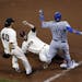 Kansas City Royals' Salvador Perez is out at first on the sliding tag of San Francisco Giants' Brandon Belt (9) Madison Bumgarner moves in to assist, 