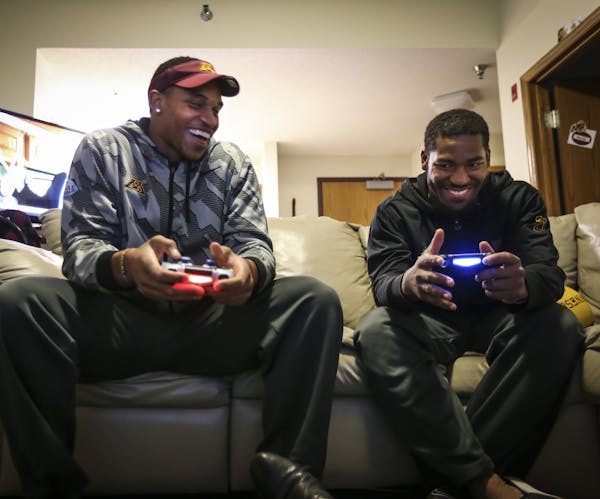 Damien Wilson, left, and David Cobb enjoy a friendly video game — when the competitive cousins from Mississippi aren’t carrying the Cophers to suc