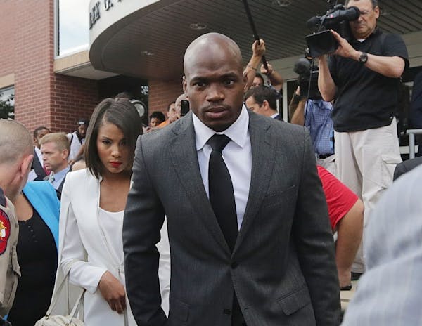 Minnesota Vikings running back Adrian Peterson leaves court accompanied by his wife, Ashley Brown Peterson, in Conroe, Texas, Wednesday, Oct. 8, 2014.