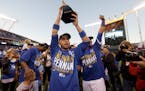 Kansas City Royals' Omar Infante holds the trophy after the Royals defeated the Baltimore Orioles to win the American League baseball championship ser