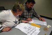 Kathy Cunnien and Dave Dalton inspected absentee ballots on Tuesday at the government center in Stillwater. The county got about 10,400 requests for b