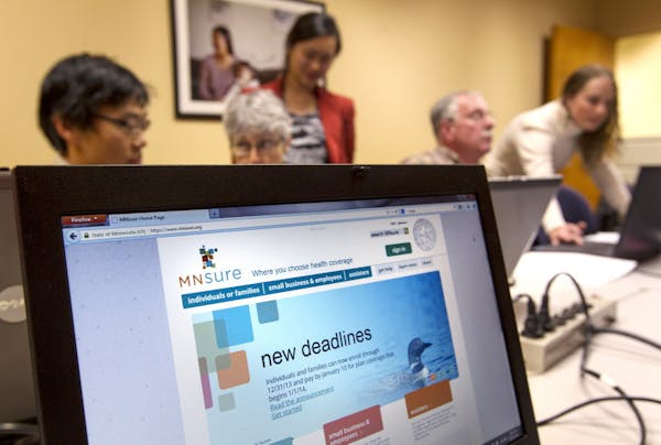 In this Dec. 21, 2013 file photo, navigators help Minnesotans sign up for MNsure health benefits before the deadline for coverage during all-day small