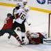 Pittsburgh Penguins' Nick Spaling, left rear, scores on Minnesota Wild goalie Darcy Kuemper during the first period of an NHL hockey game, Tuesday, No