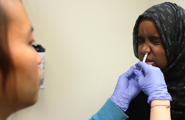 Raqiyo Dahir, 14, of St. Paul, received the nasal flu vaccine administered by registered nurse Kellie Xiong.