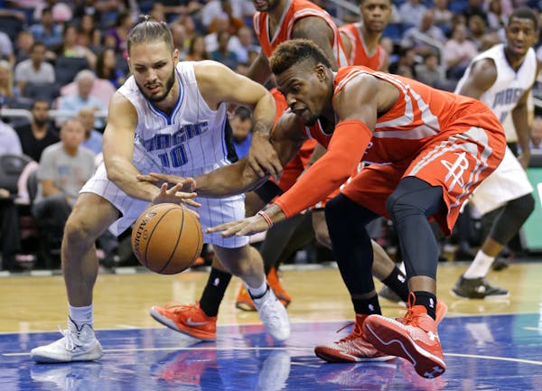 Orlando Magic's Evan Fournier (10), of France, battles Houston Rockets' Jeff Adrien, right, for a loose ball during the second half of an NBA preseaso