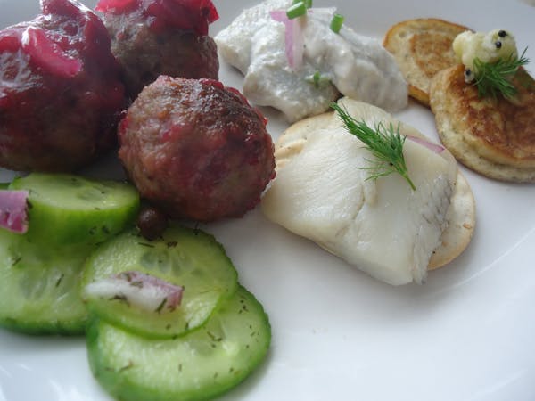 A party platter:  Quick pickled cucumbers, modern Swedish meatballs with lingonberry reduction, pickled herring and pickled herring with sour cream 