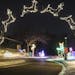 A slow camera shutter speed shows the full moving reindeer arch as a car drives through at the Holiday Lights in the Park at Phalen Park in St. Paul, 