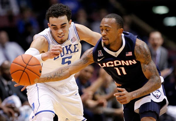 Connecticut guard Ryan Boatright (11) makes a steal against Duke guard Tyus Jones (5) during the first half of an NCAA college basketball game, Thursd