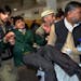 Pakistani volunteers carry a student injured in the shootout at a school under attack by Taliban gunmen, at a local hospital in Peshawar, Pakistan,Tue
