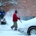 Workers remove a fresh blanket of snow outside Mayflower Church on Diamond Lake Road near I-35W Saturday, Dec. 27, 2014, in Minneapolis, MN.