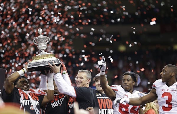 Ohio State players and staff hold the Sugar Bowl Classic trophy after the Sugar Bowl NCAA college football playoff semifinal game against Alabama, Fri